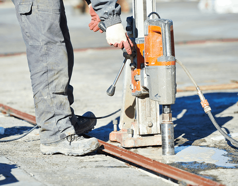 A man is using a machine to drill a hole in the ground.
