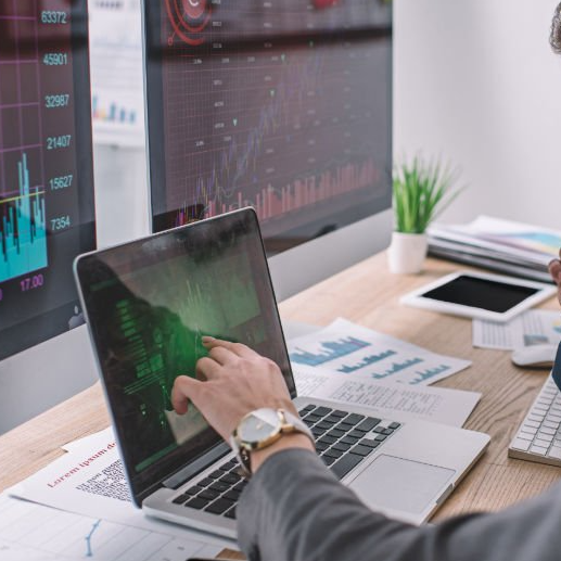 A person is using a laptop computer with a graph on the screen