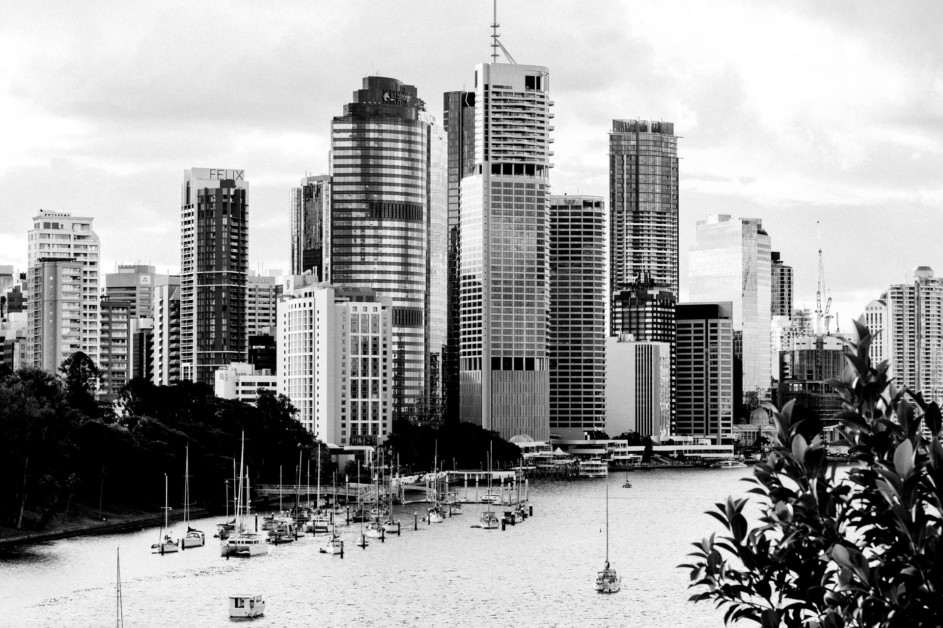 A black and white photo of a city skyline with boats in the water