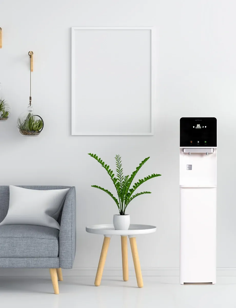 Fontaine à eau blanche dans un salon minimaliste avec plante et tableau encadré.