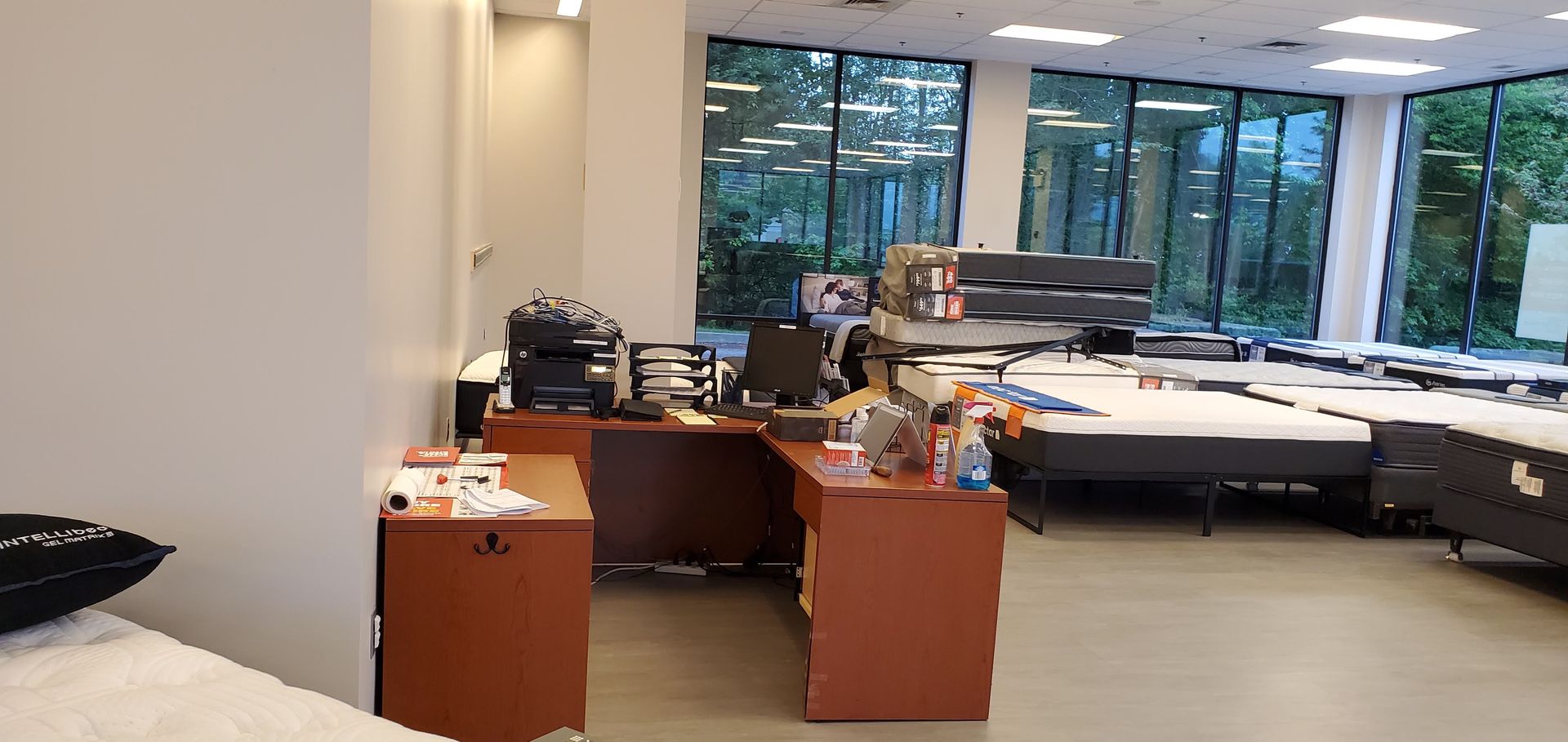 A store interior with office desk and mattresses.