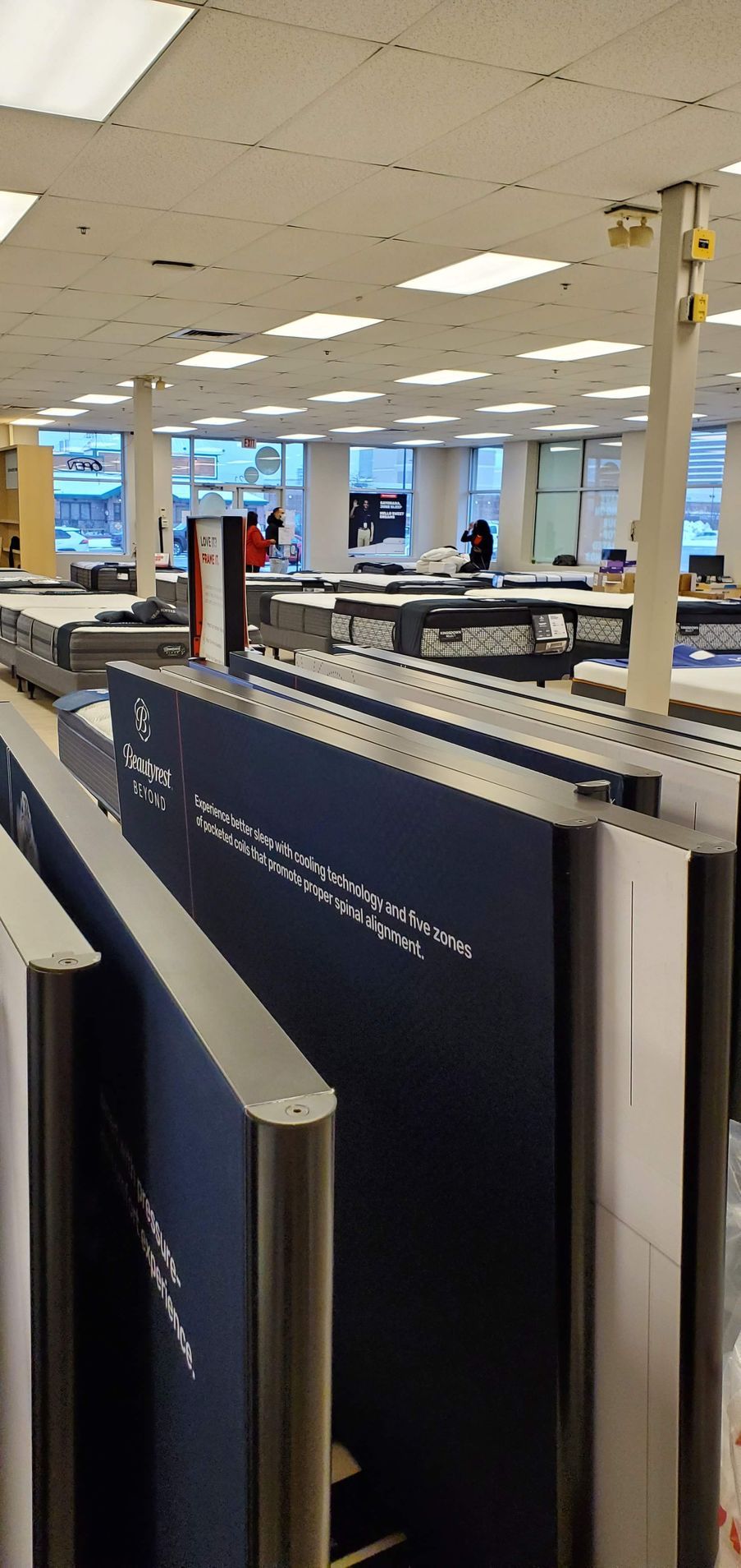 View of an office or library interior, featuring rows of dark blue partitions with silver trim.