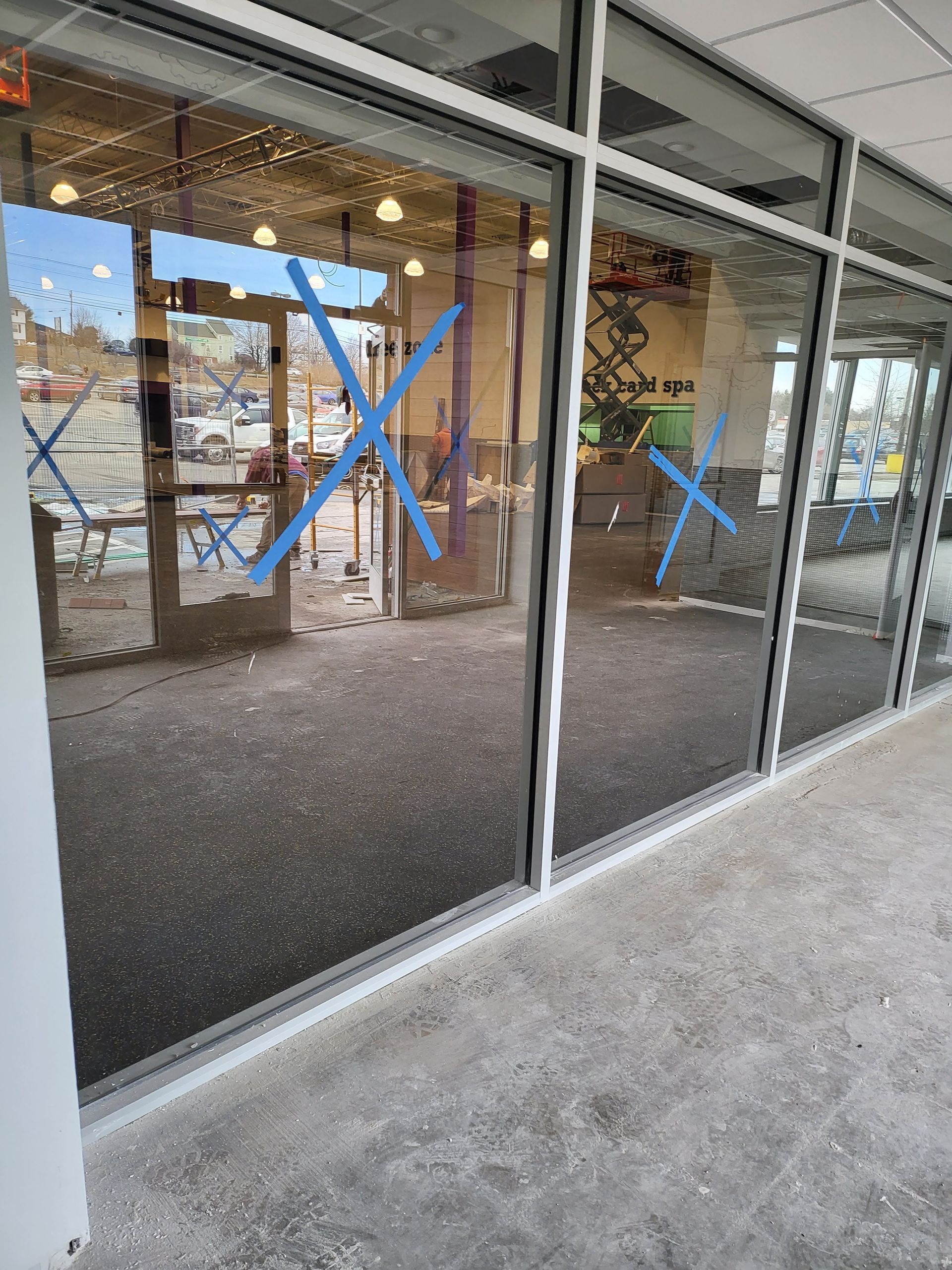 Exterior view of a building with large glass windows marked with blue xs.