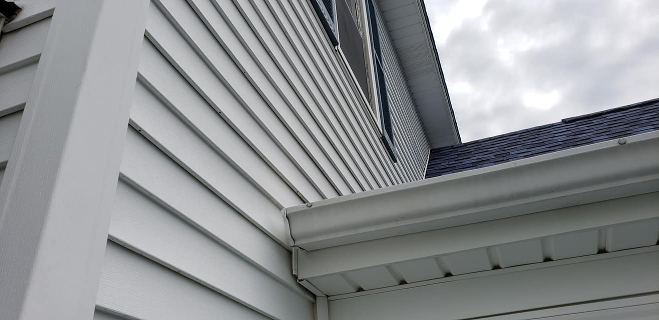 A close up of a white house with a blue roof.