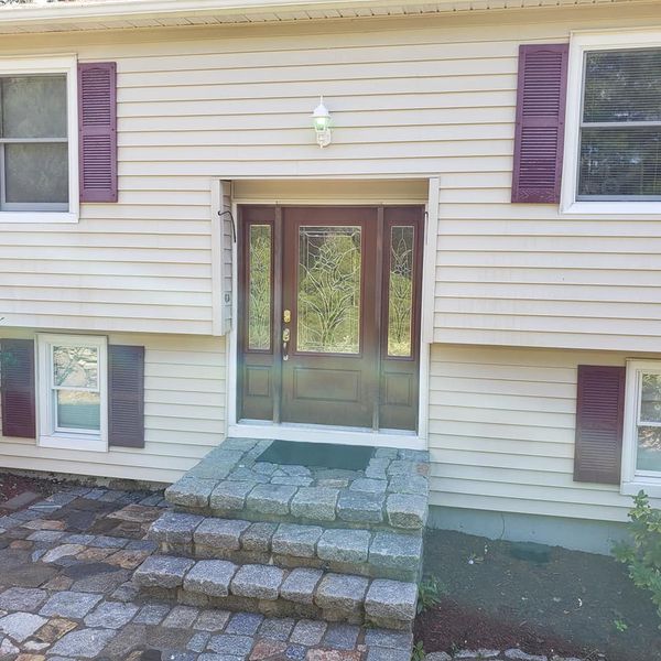 The front door of a house with purple shutters