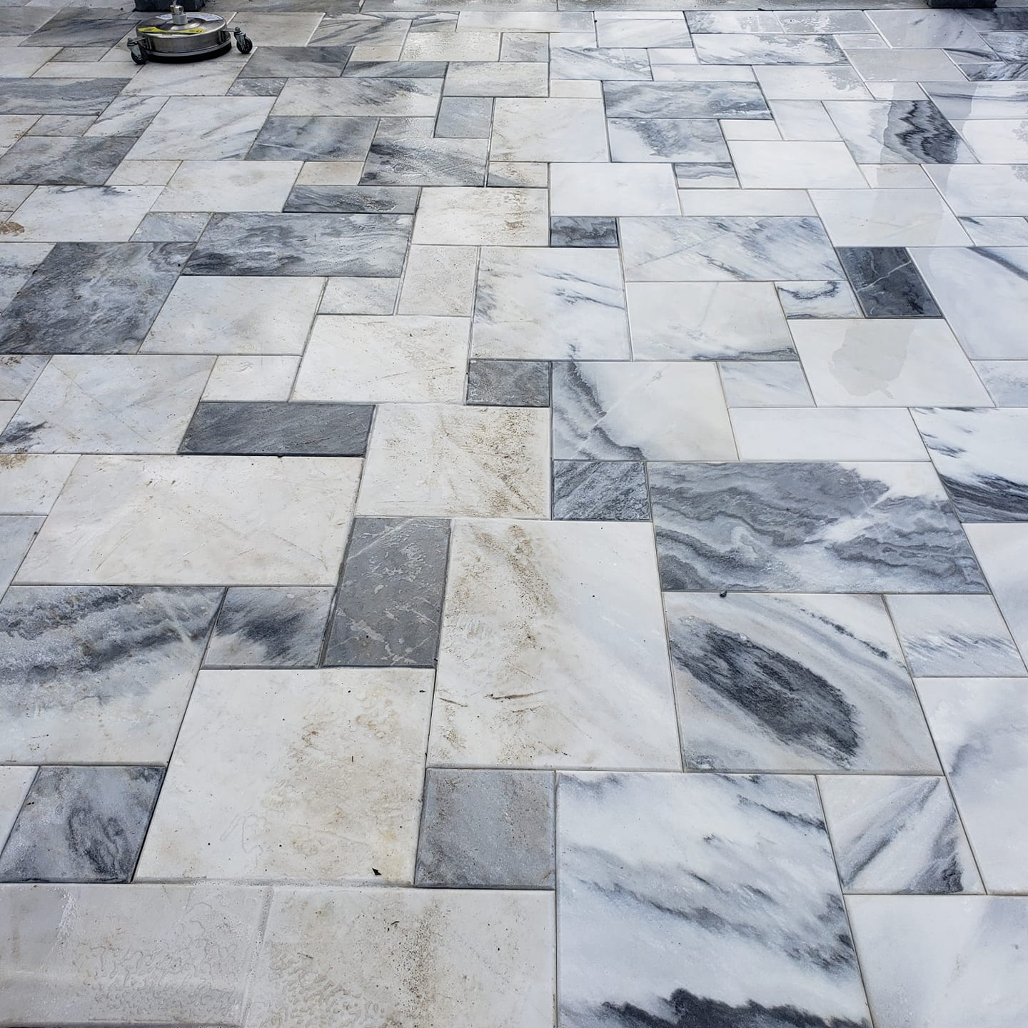 A person is cleaning a marble floor with a machine