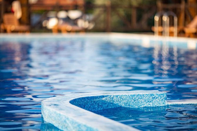Top view of swimming pool with clear water on vacation on sunset background 
