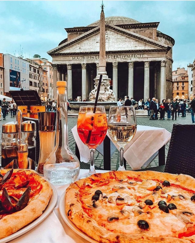 Pizza e bevande su un tavolo di fronte al Pantheon a Roma.