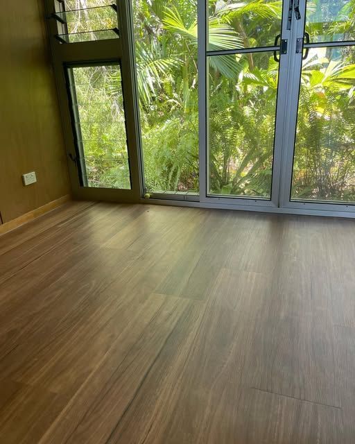 A Room With a Wooden Floor and a Sliding Glass Door — John Chisholm Flooring in Manunda,  QLD