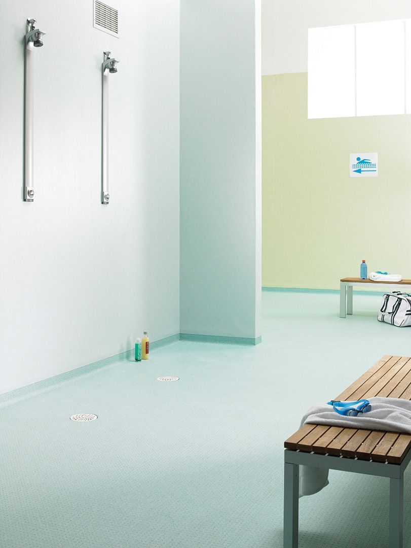 A Locker Room With a Wooden Bench in the Middle — John Chisholm Flooring in Cairns,  QLD