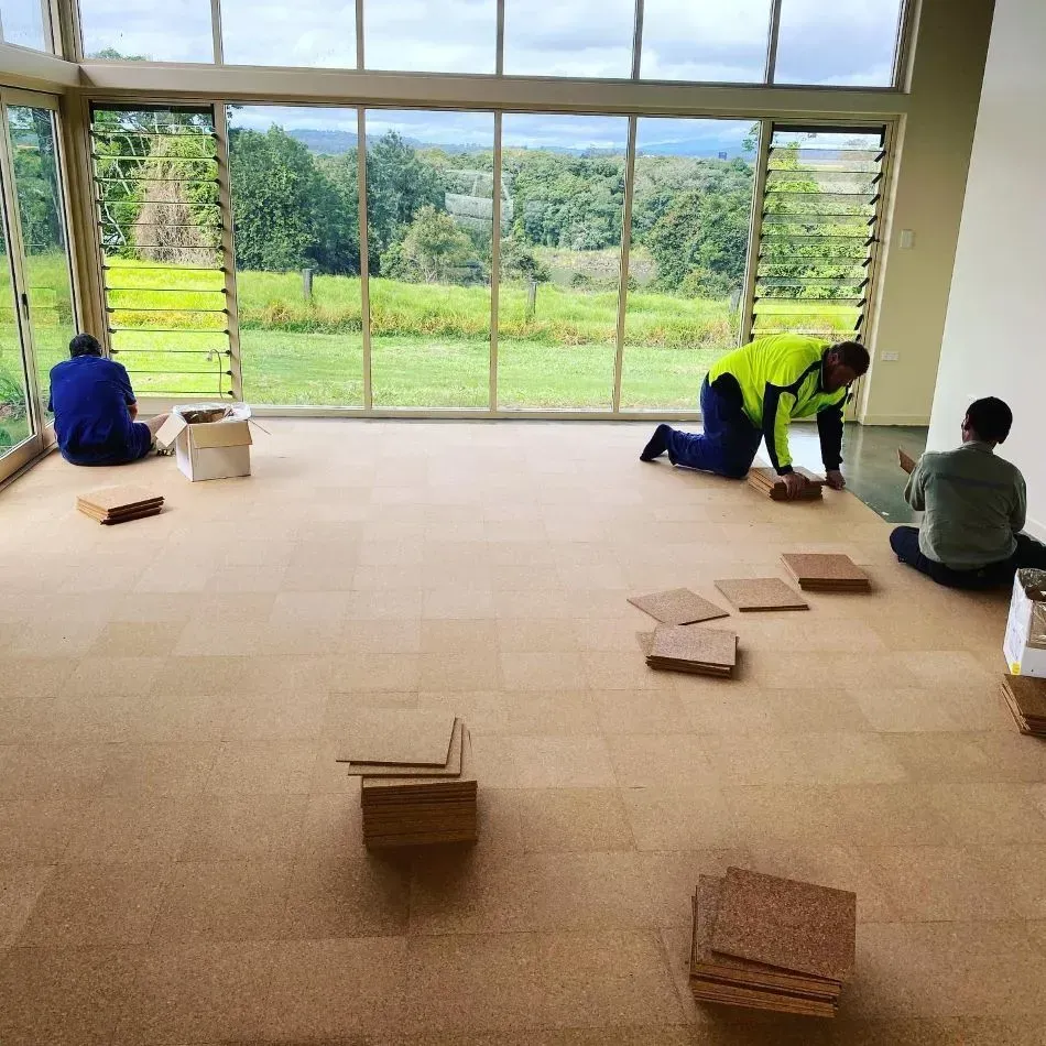 A Group of People Are Working on a Cork Floor — John Chisholm Flooring in Mareeba, QLD