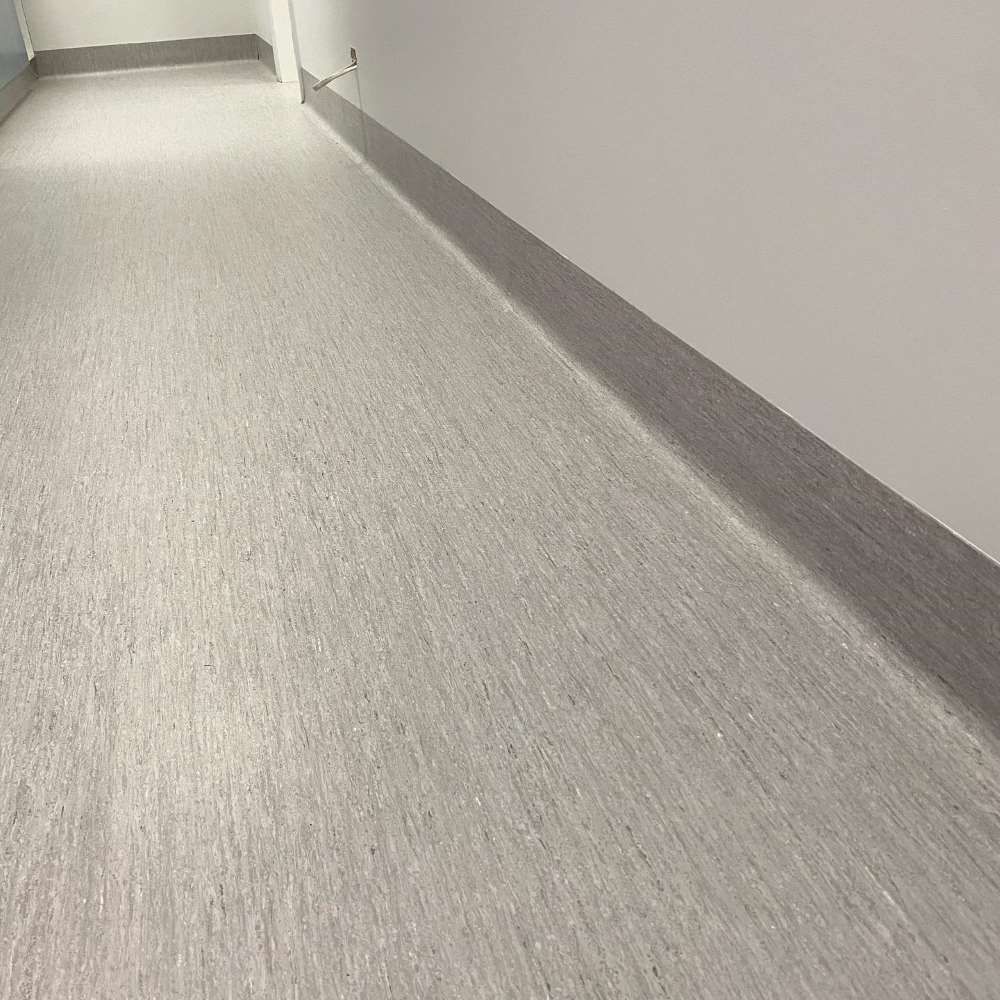A Long Hallway With a White Floor and a White Wall — John Chisholm Flooring in Manunda, QLD