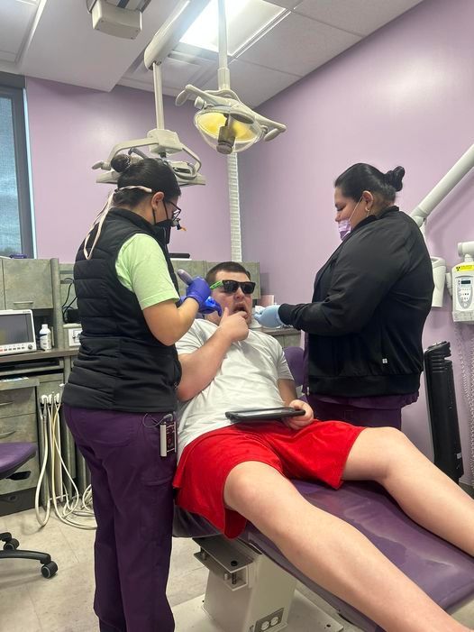 A man in red shorts is sitting in a dental chair