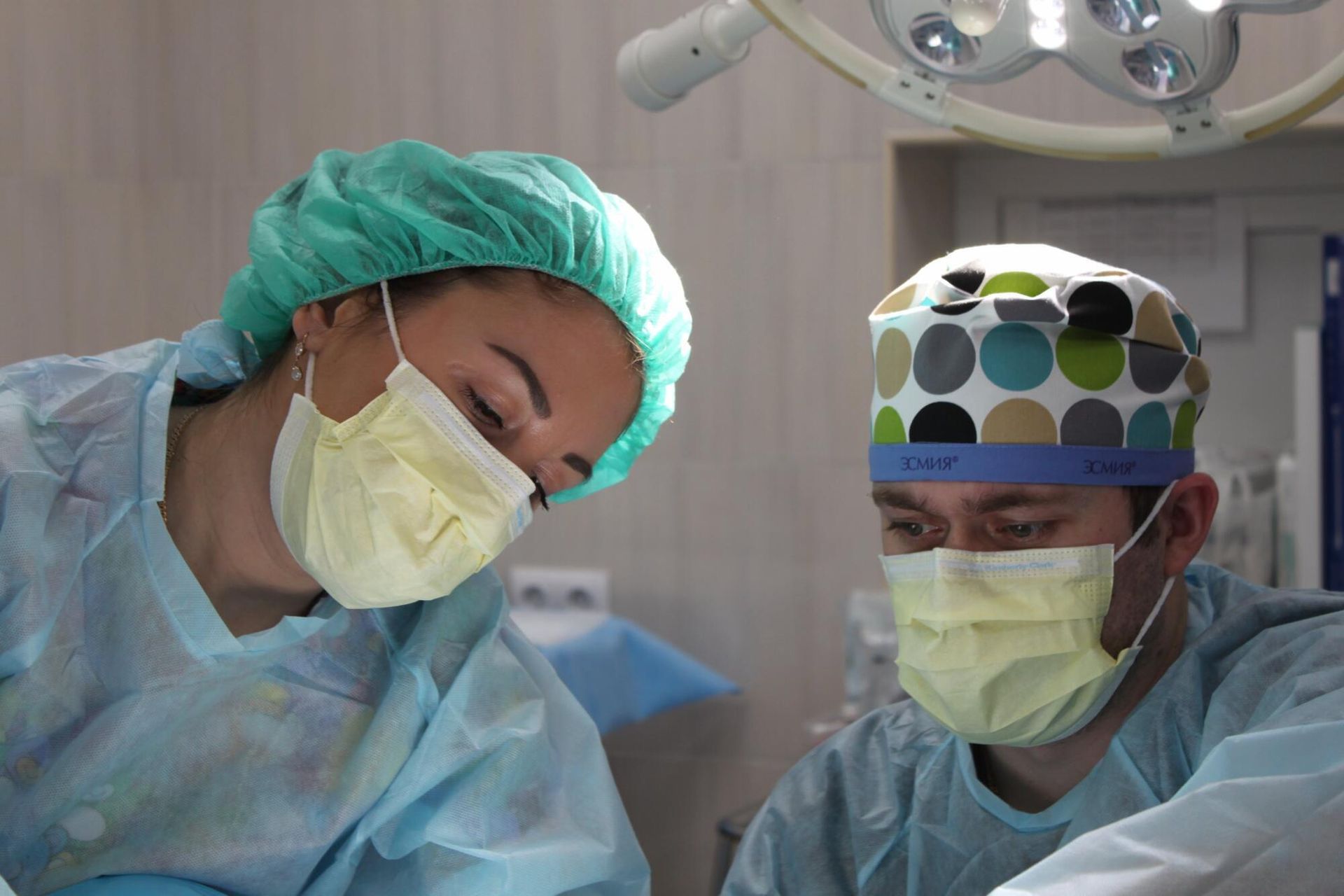 a man and a woman are wearing masks in an operating room .