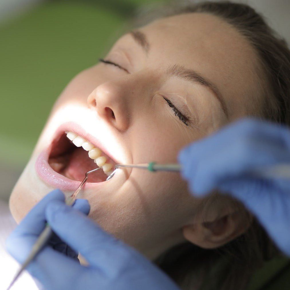 Dentist cleaning patient teeth