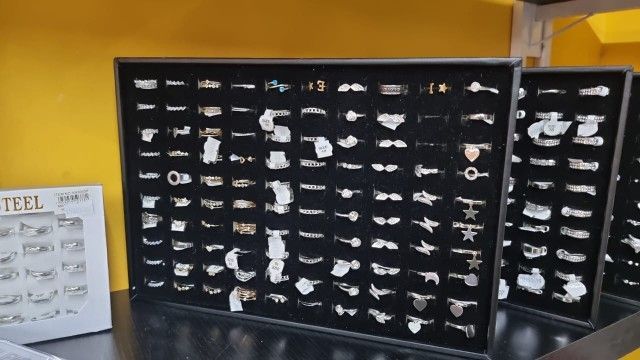 Vitrina de joyería con numerosos anillos sobre fondo de terciopelo negro.