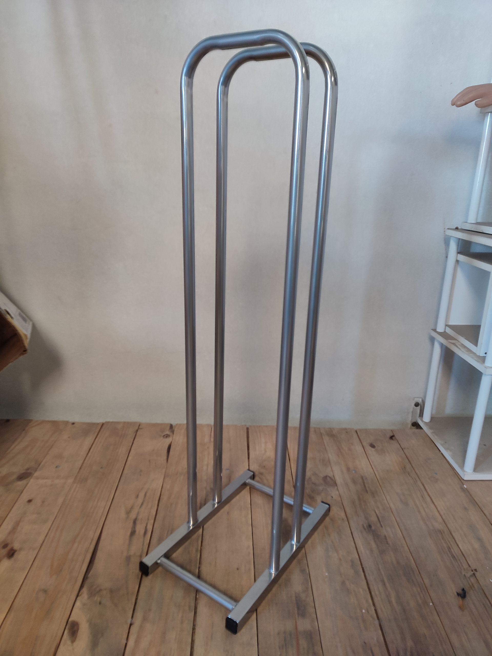 Toallero metálico con tres barras verticales.