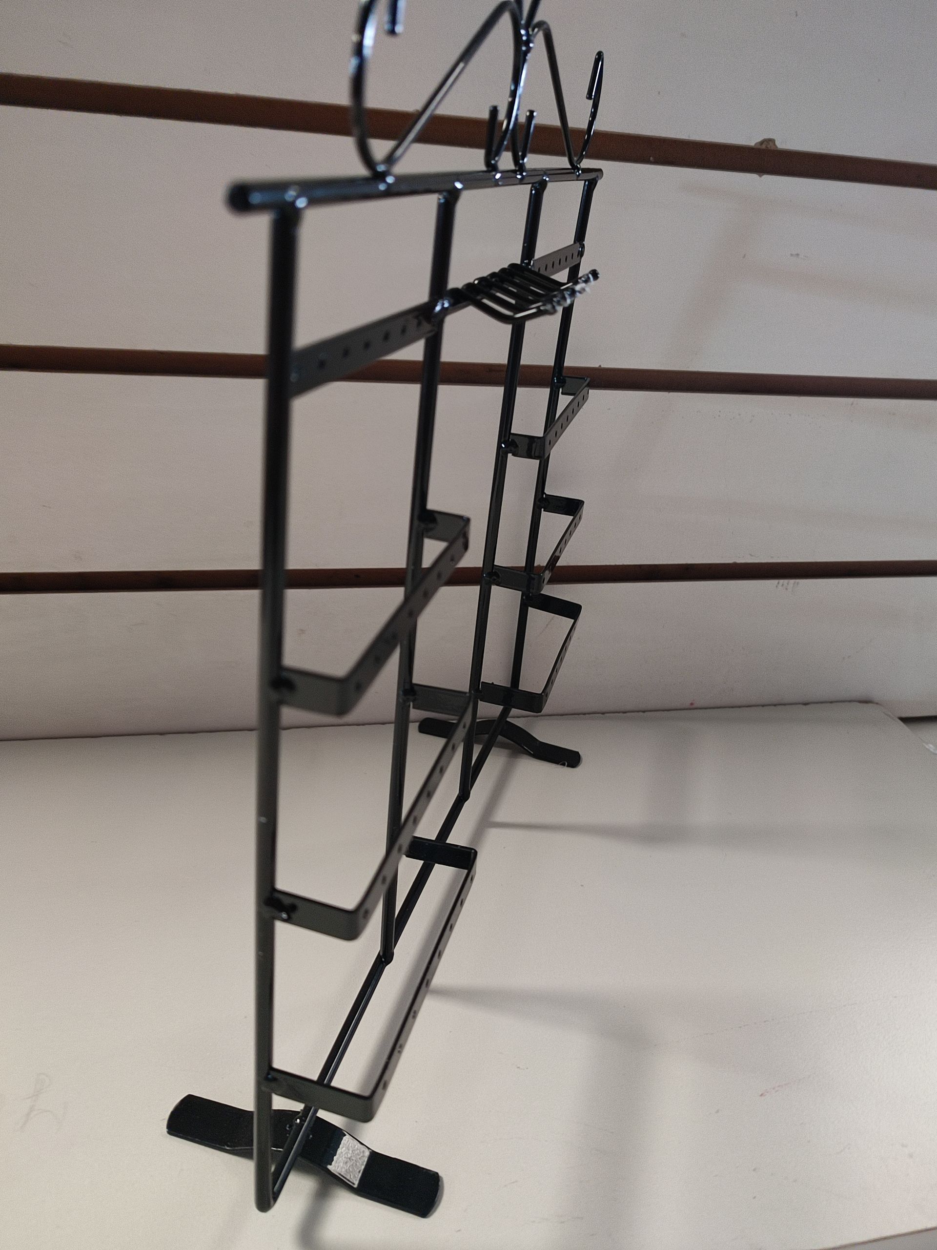 Expositor de metal negro con múltiples estantes en ángulo.