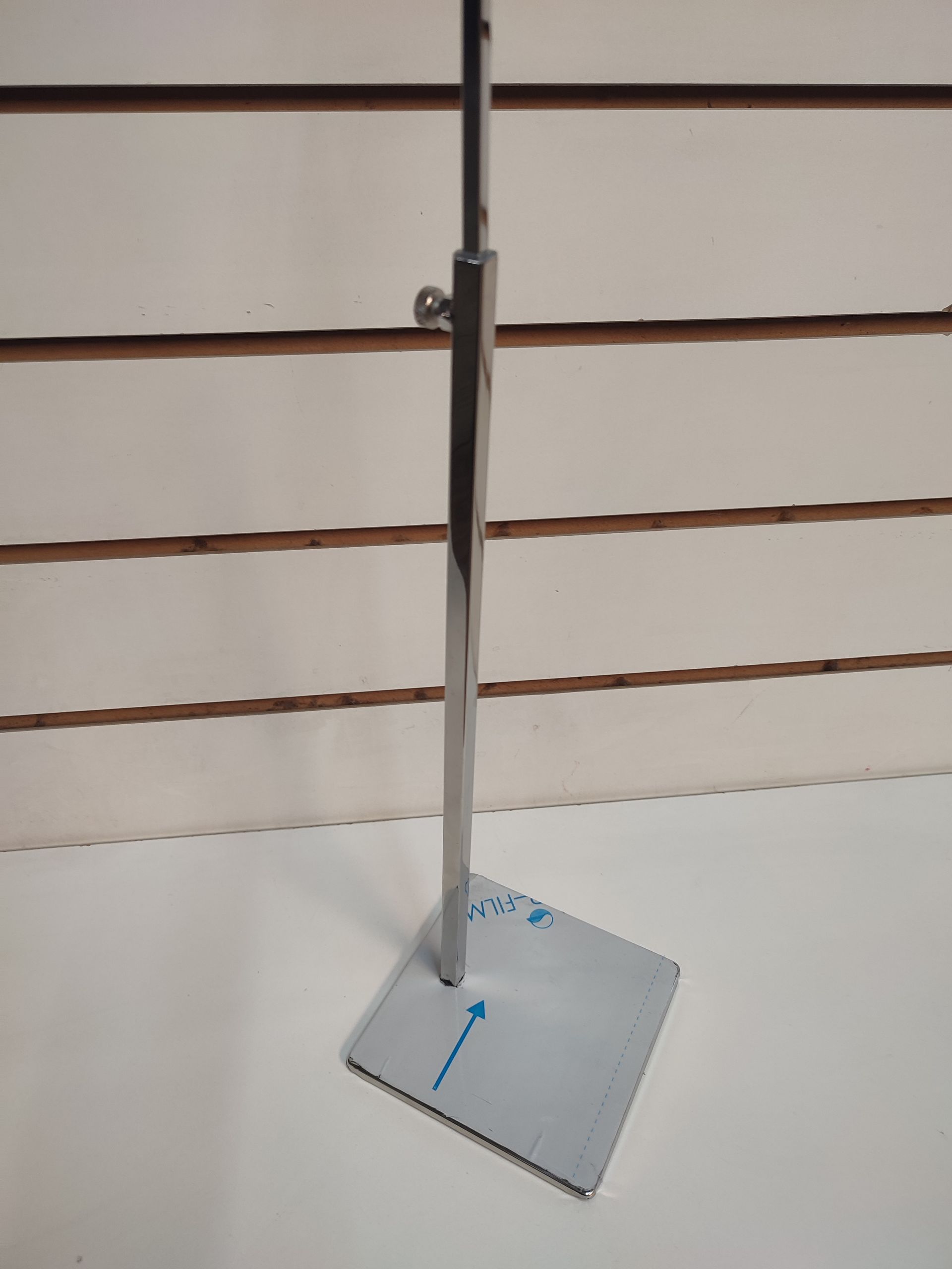 Expositor de acero inoxidable con base cuadrada y mástil regulable.