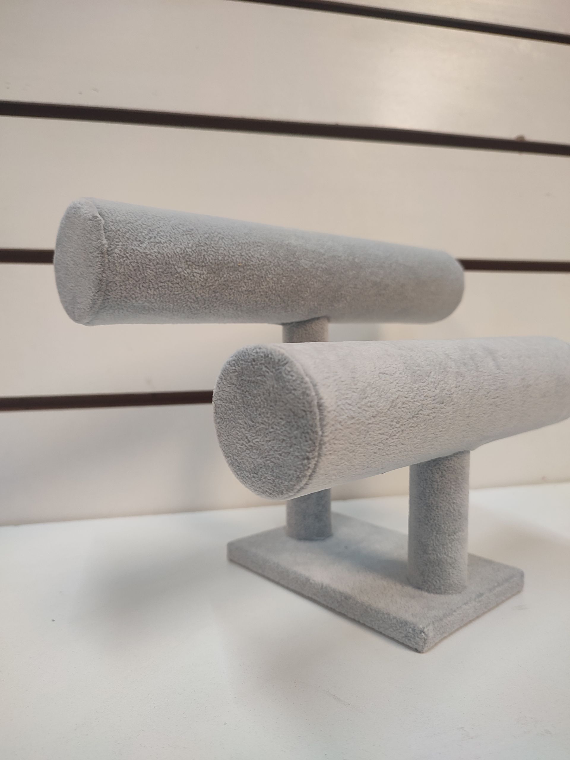 Expositor de joyas en terciopelo gris, sujetando dos barras horizontales.