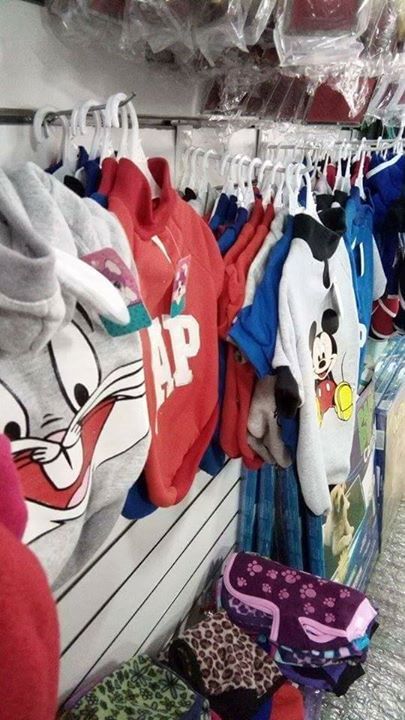 Ropa en perchas, incluidas camisetas de personajes de dibujos animados, exhibidas en una tienda.