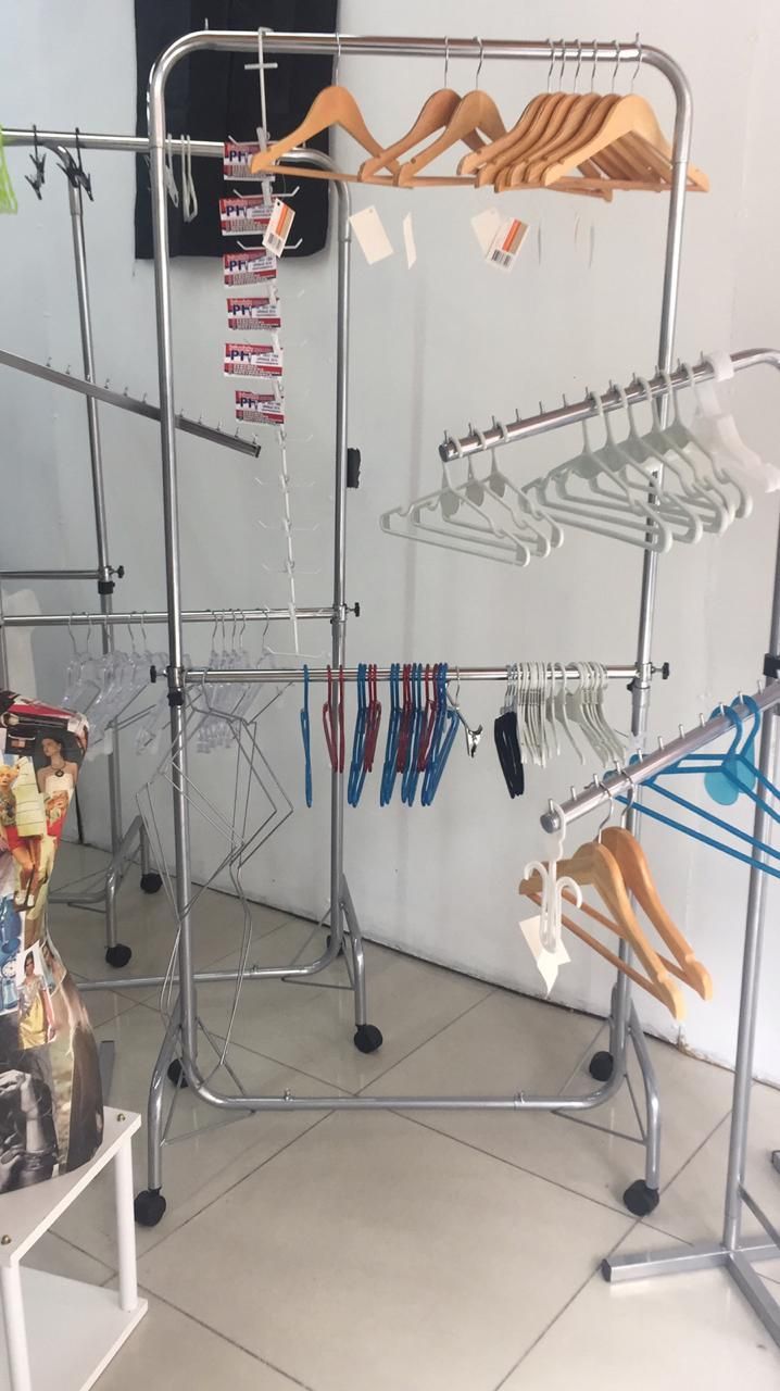 Percheros que muestran diversas perchas y artículos, en el interior.