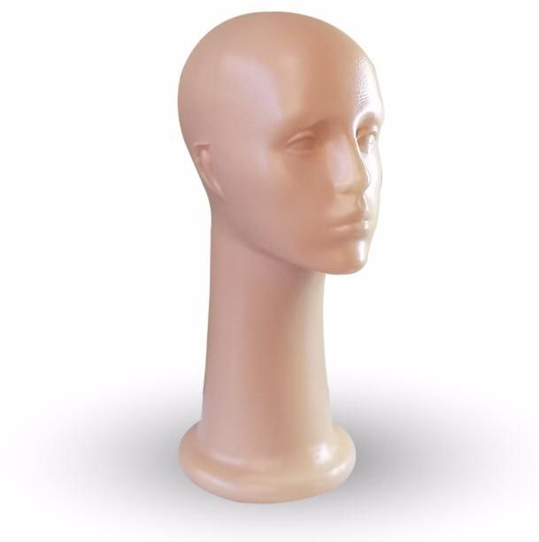 Cabeza de maniquí, color beige, lisa, inclinada, sobre pedestal.