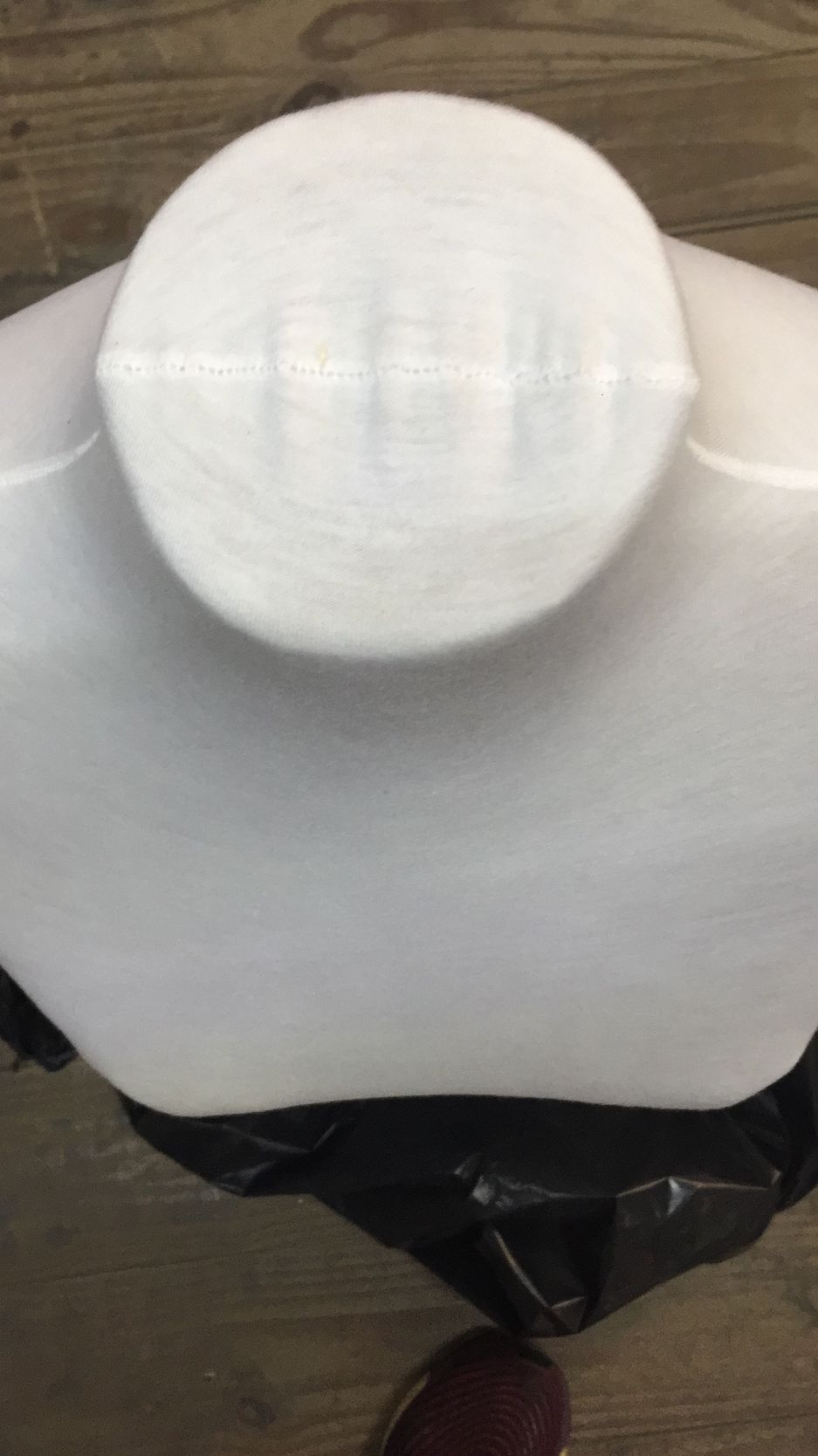 Vista de arriba hacia abajo de un objeto cilíndrico blanco que descansa sobre una superficie blanca