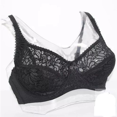 Sujetador de encaje negro sobre una base de plástico transparente, expuesto sobre un fondo blanco.