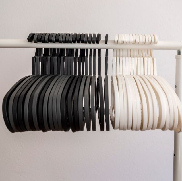 Perchas de ropa en blanco y negro colgadas en un estante blanco.