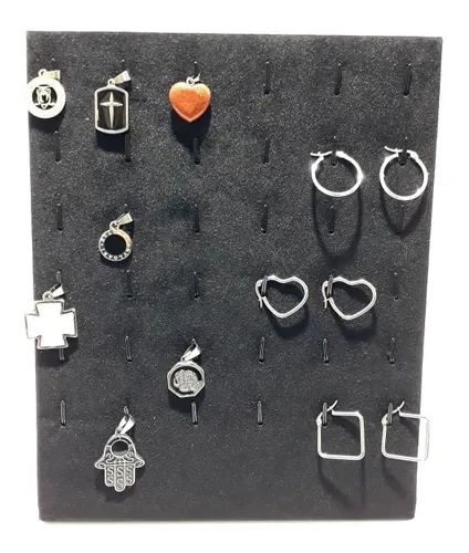 Tablero de exhibición negro con varios colgantes y pendientes de joyería de plata.