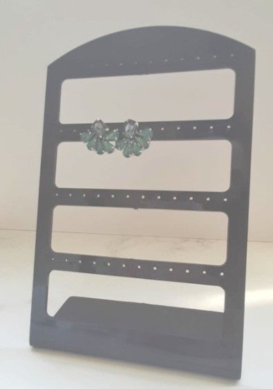 Expositor de pendientes negro con dos pares de pendientes verdes.