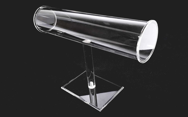 Exhibidor de joyas de acrílico transparente, en forma de T con brazo cilíndrico y base cuadrada.