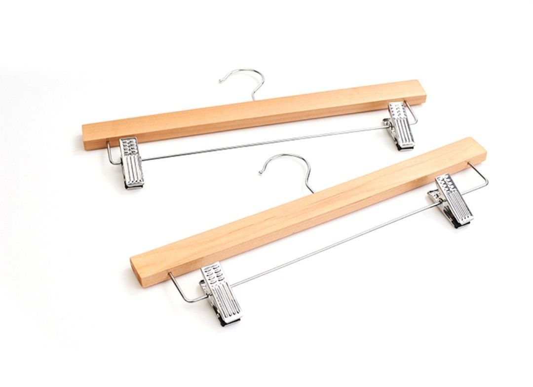 Dos perchas de madera con pinzas metálicas.