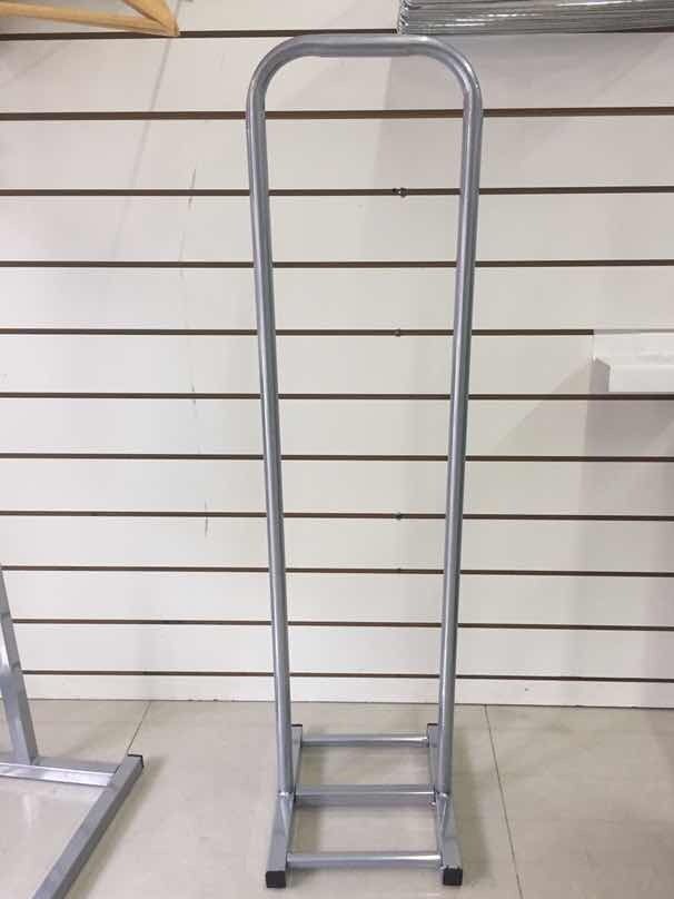 Porta carteles de metal plateado, marco rectangular alto con parte superior redondeada, dos peldaños en la parte inferior.