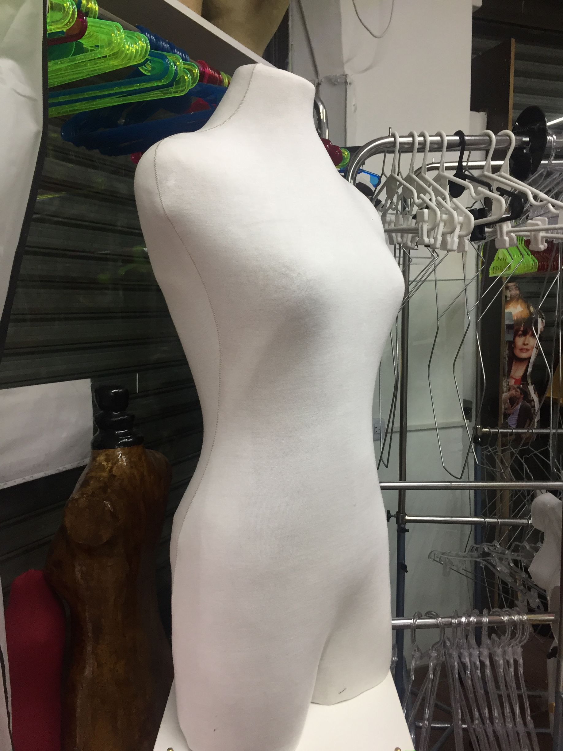 Torso de maniquí blanco en una tienda, mostrando una forma curva.