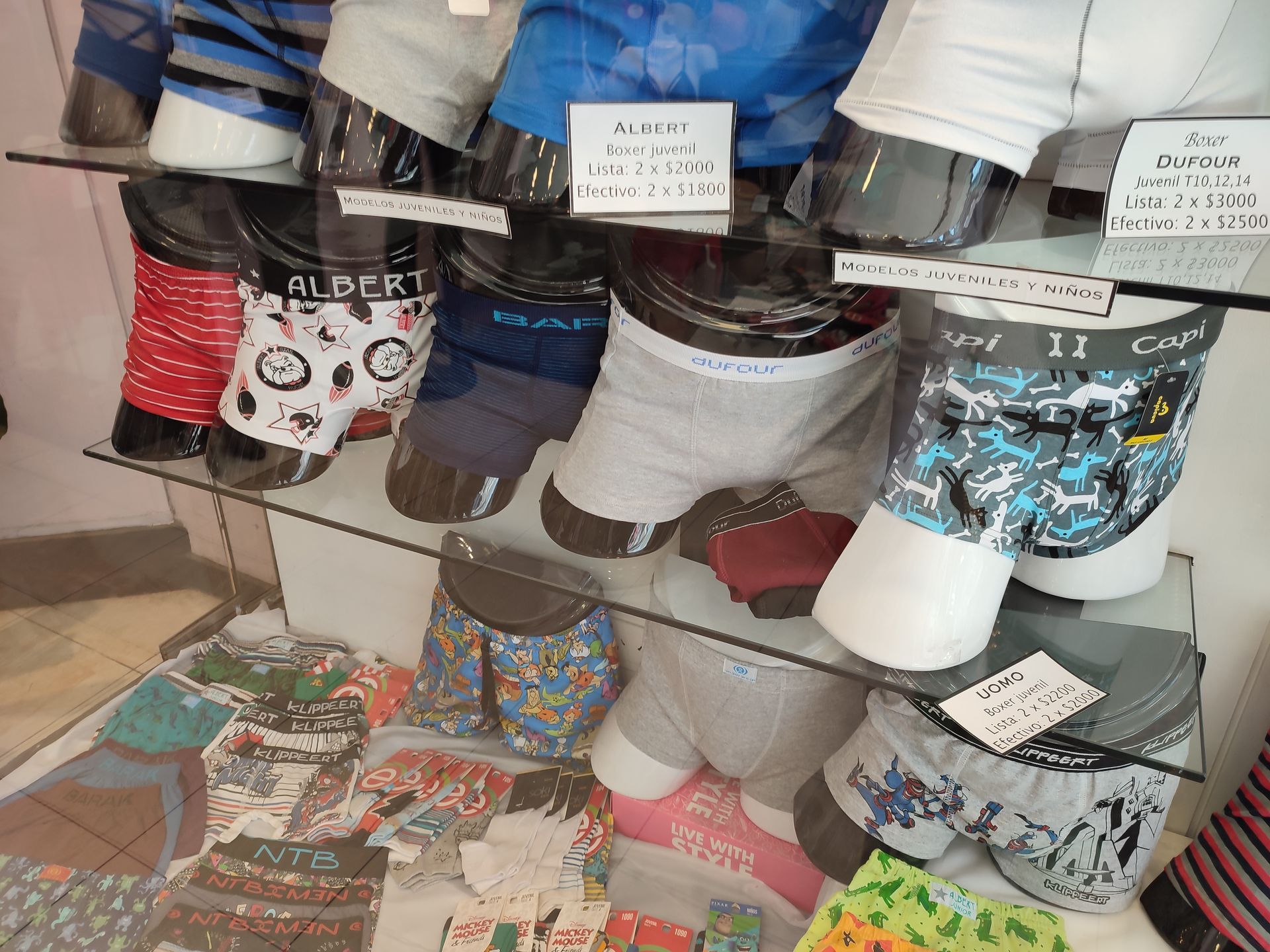 Exhibición de ropa interior en una tienda, con varios estilos y colores de calzoncillos bóxer.