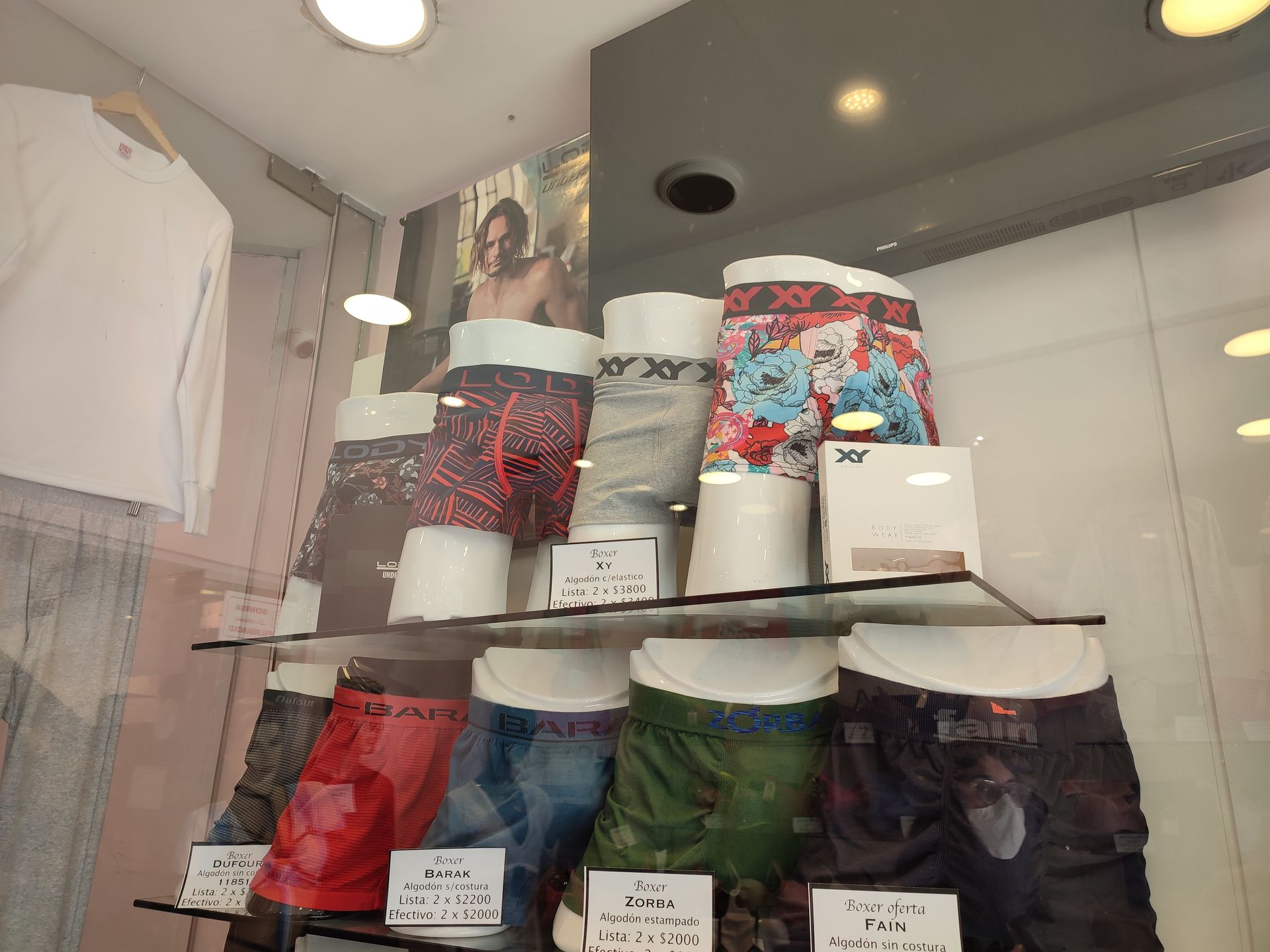 Exhibición de ropa interior masculina estampada en el escaparate de una tienda, dispuesta en estantes.
