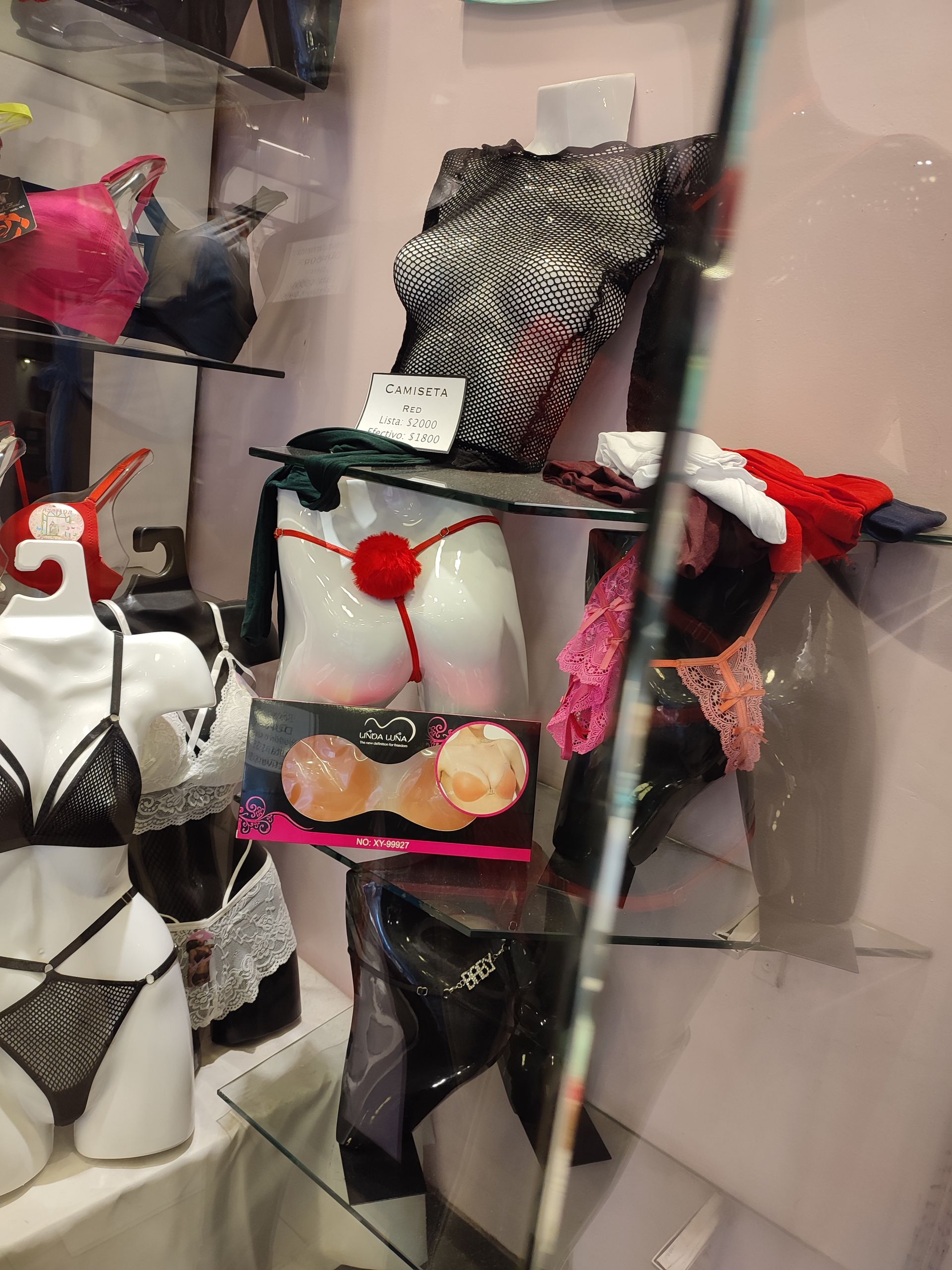 Maniquíes exhibiendo lencería en un escaparate, varios estilos y colores.