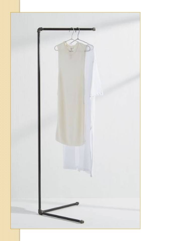 Perchero de metal negro que contiene dos prendas blancas.
