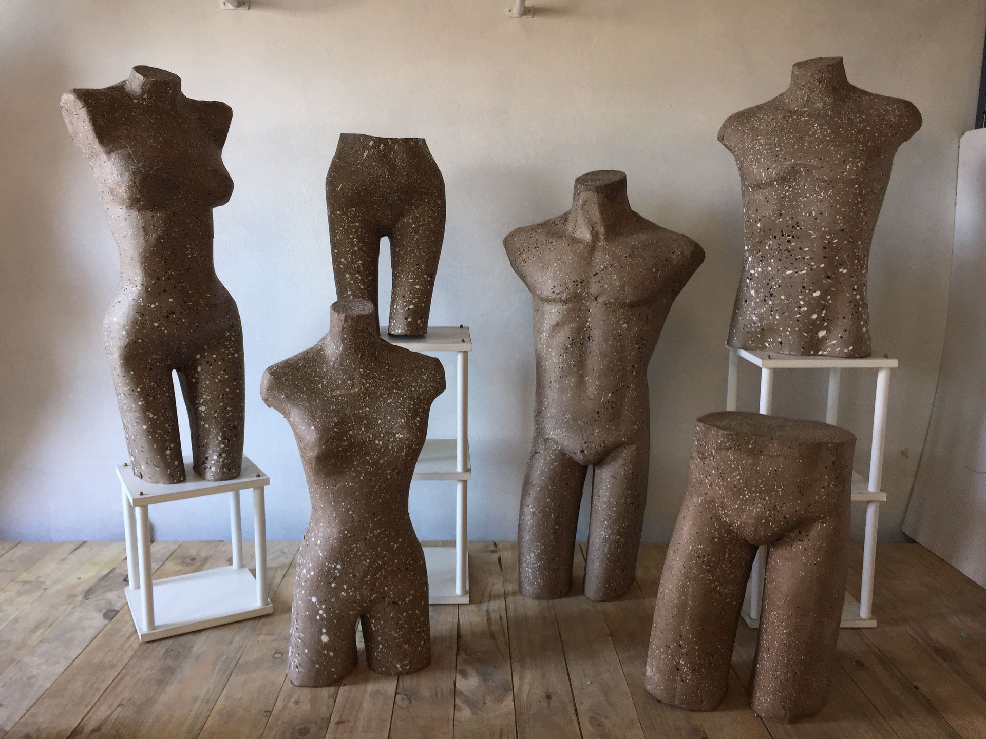 Siete esculturas de torso y parte inferior del cuerpo realizadas en material moteado