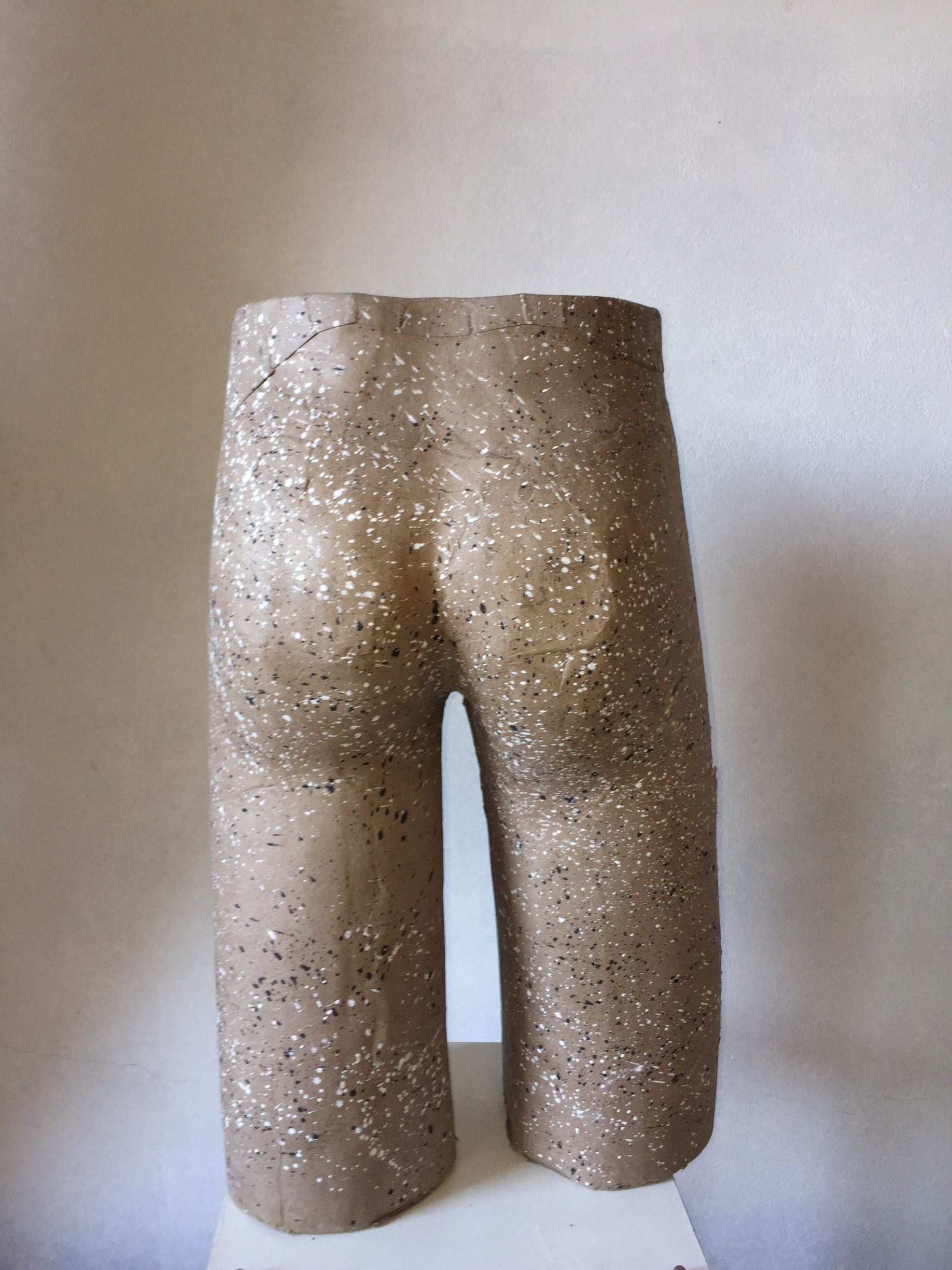 Escultura de piedra abstracta, de pie, con textura moteada.