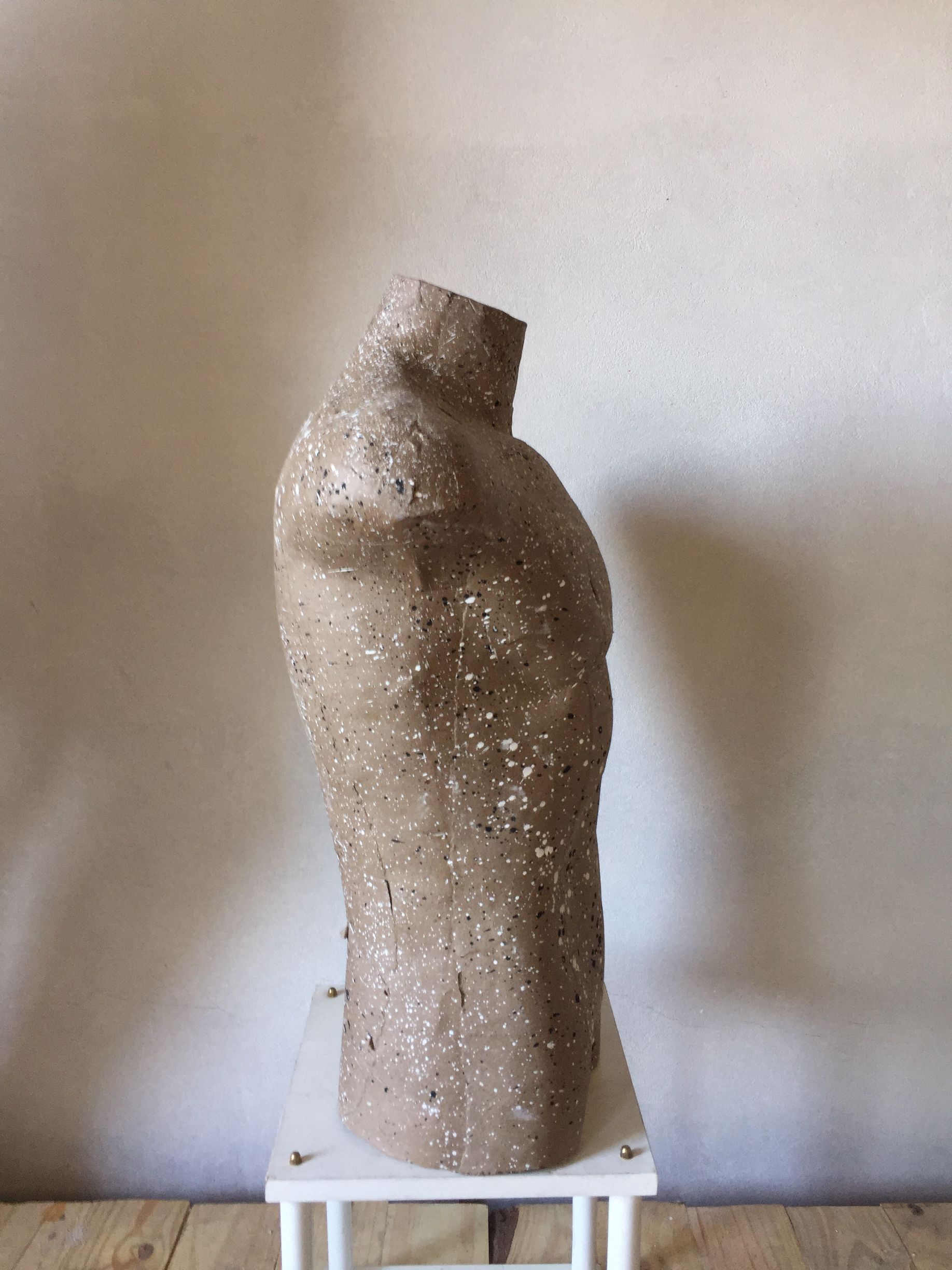 Escultura torso de forma humana, moteada y de tonos marrones
