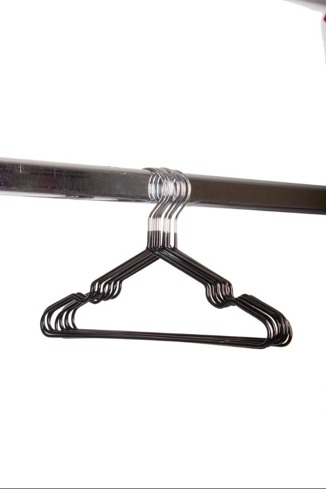 Perchas de metal negro sobre barra de metal.