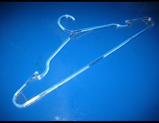 Percha de ropa de plástico transparente sobre superficie azul.