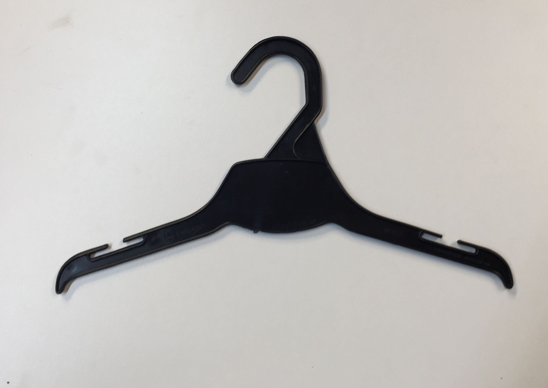 Percha de ropa de plástico negra sobre fondo blanco.