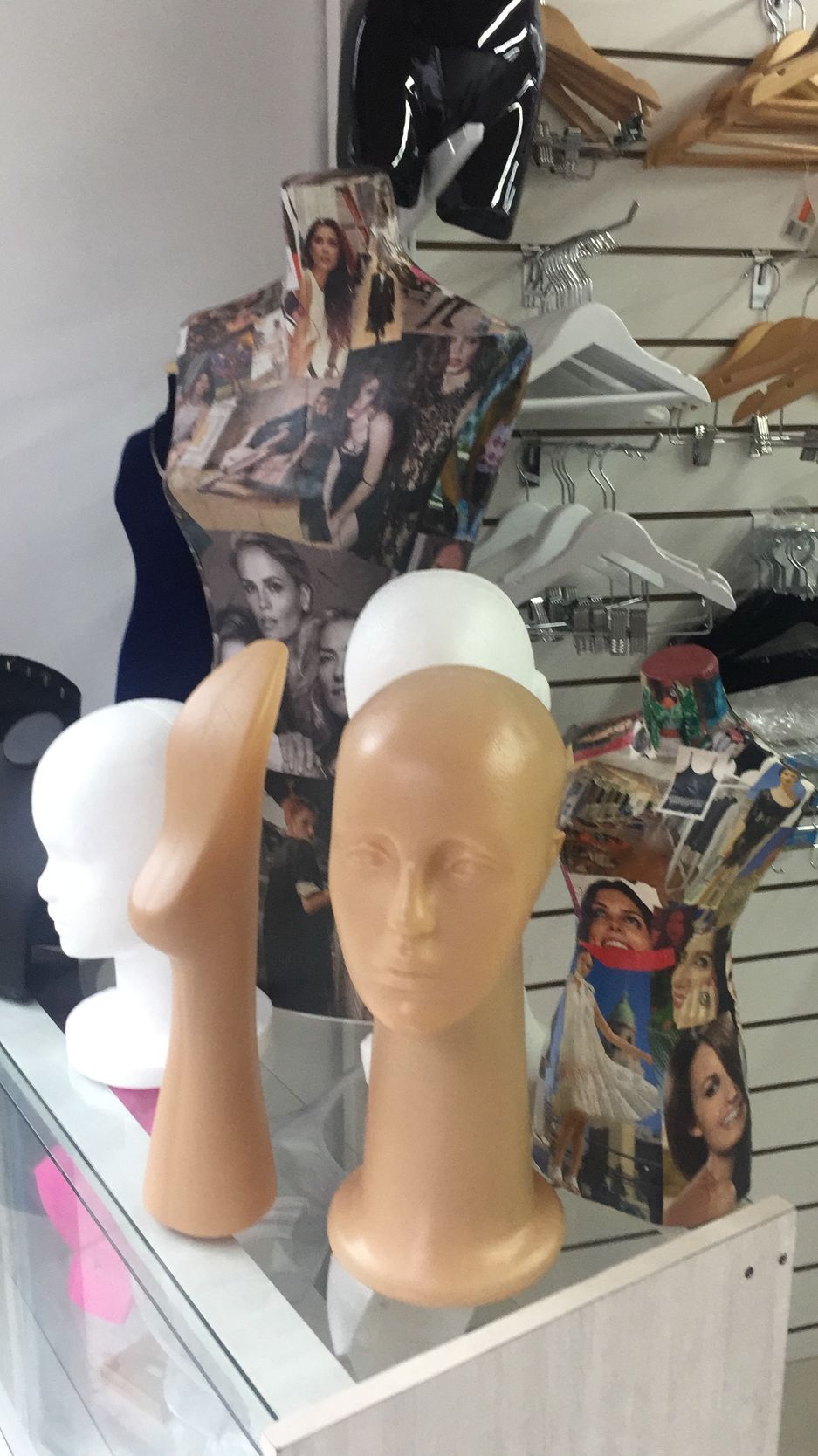 Torsos y cabezas de maniquíes en un estante de exhibición