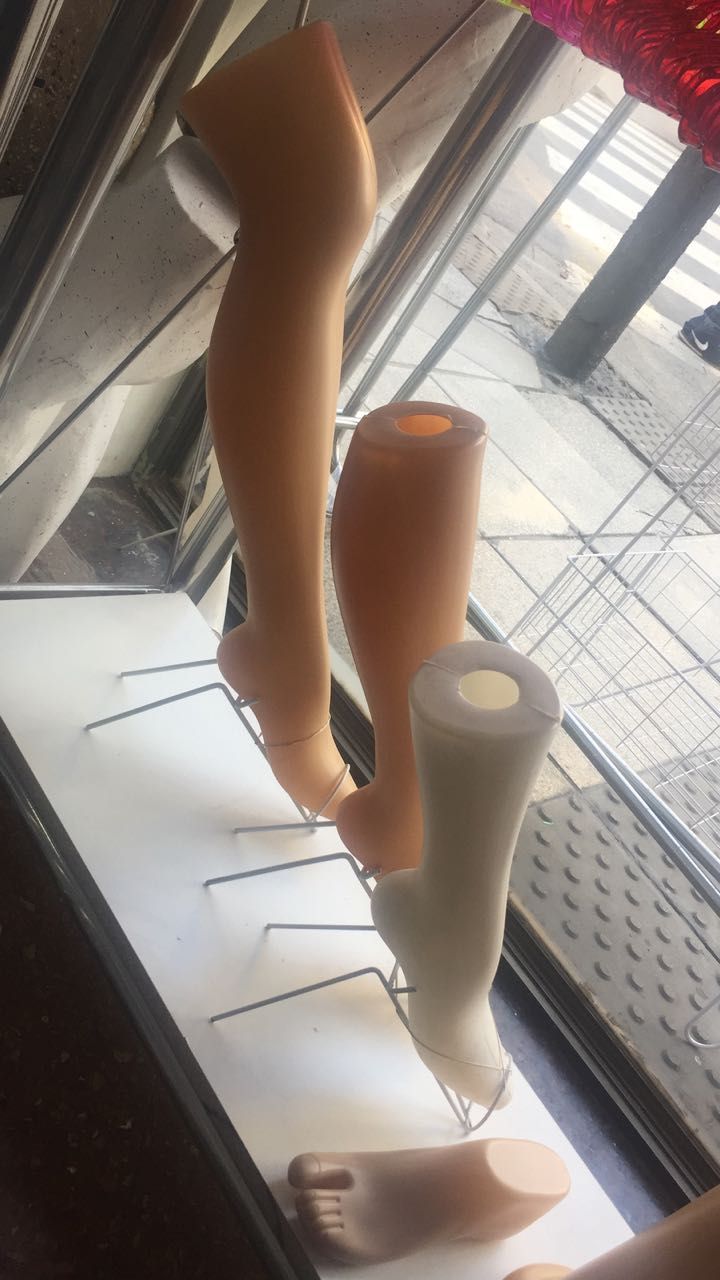 Piernas de maniquí en la vitrina de una tienda, algunas con pies adjuntos