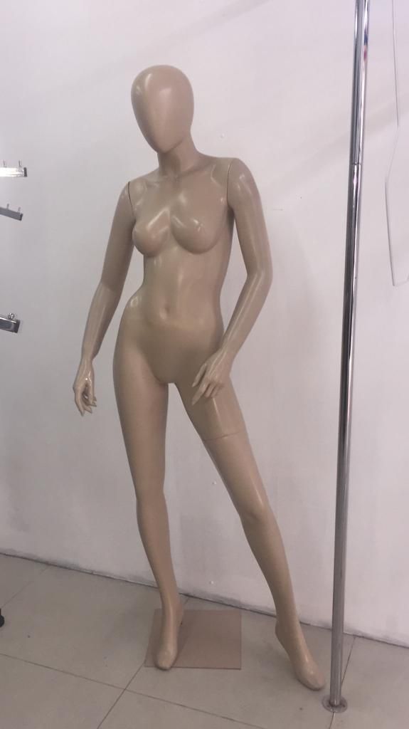 Un maniquí con un tono de piel neutro se encuentra en una tienda. 
