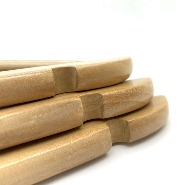 Perchas de madera, apiladas, con hombros entallados.